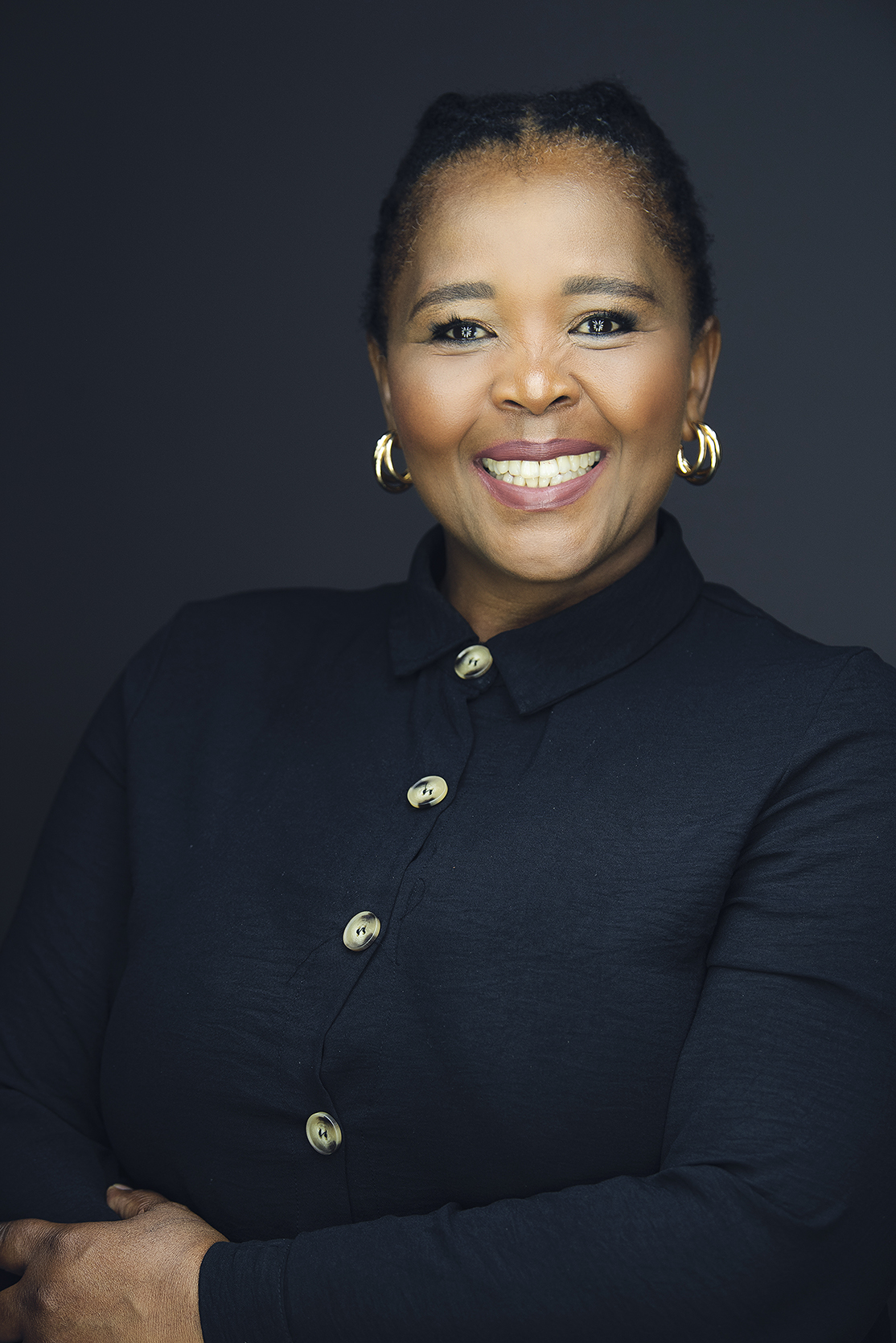 Professional female corporate headshot on dark studio backdrop by Kevin Mark Pass Photography, makeup by Storm Pass Makeup